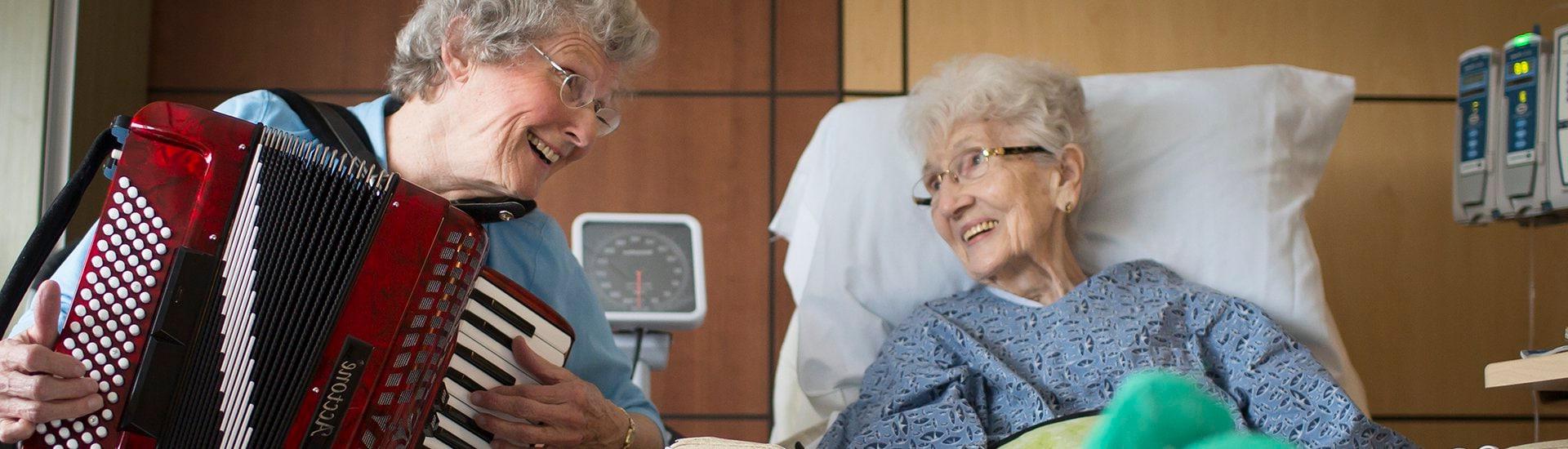 Volunteer Accordionist Doris plays for a patient